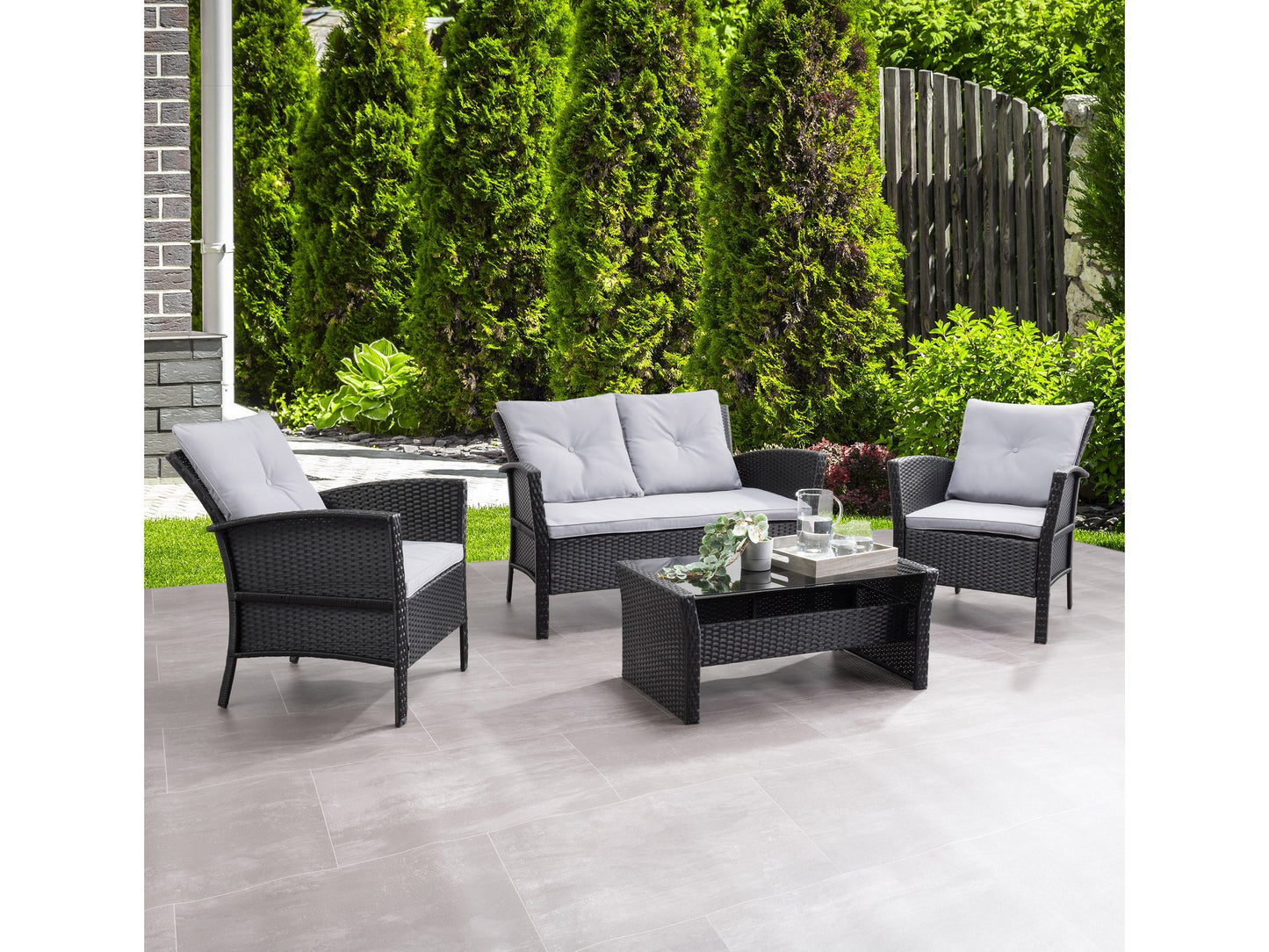 Black and grey wicker patio set, 4-piece, featuring a loveseat, two armchairs, and a glass-top coffee table, with weather-resistant cushions and a modern design suitable for outdoor spaces.