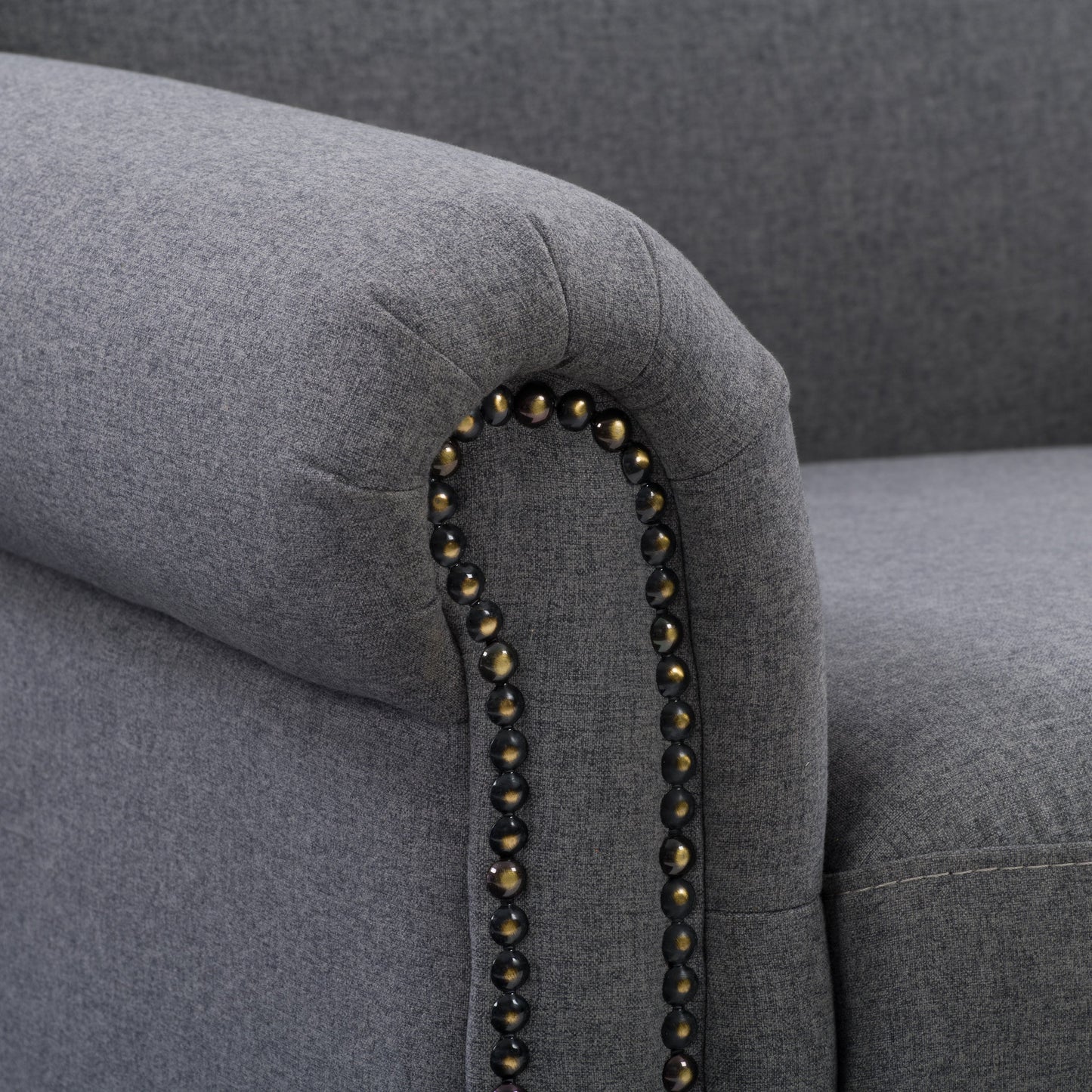 Grey armchair with plush upholstery, sleek wooden legs, and tufted backrest. The chair features a modern design with comfortable armrests, perfect for living rooms or offices.