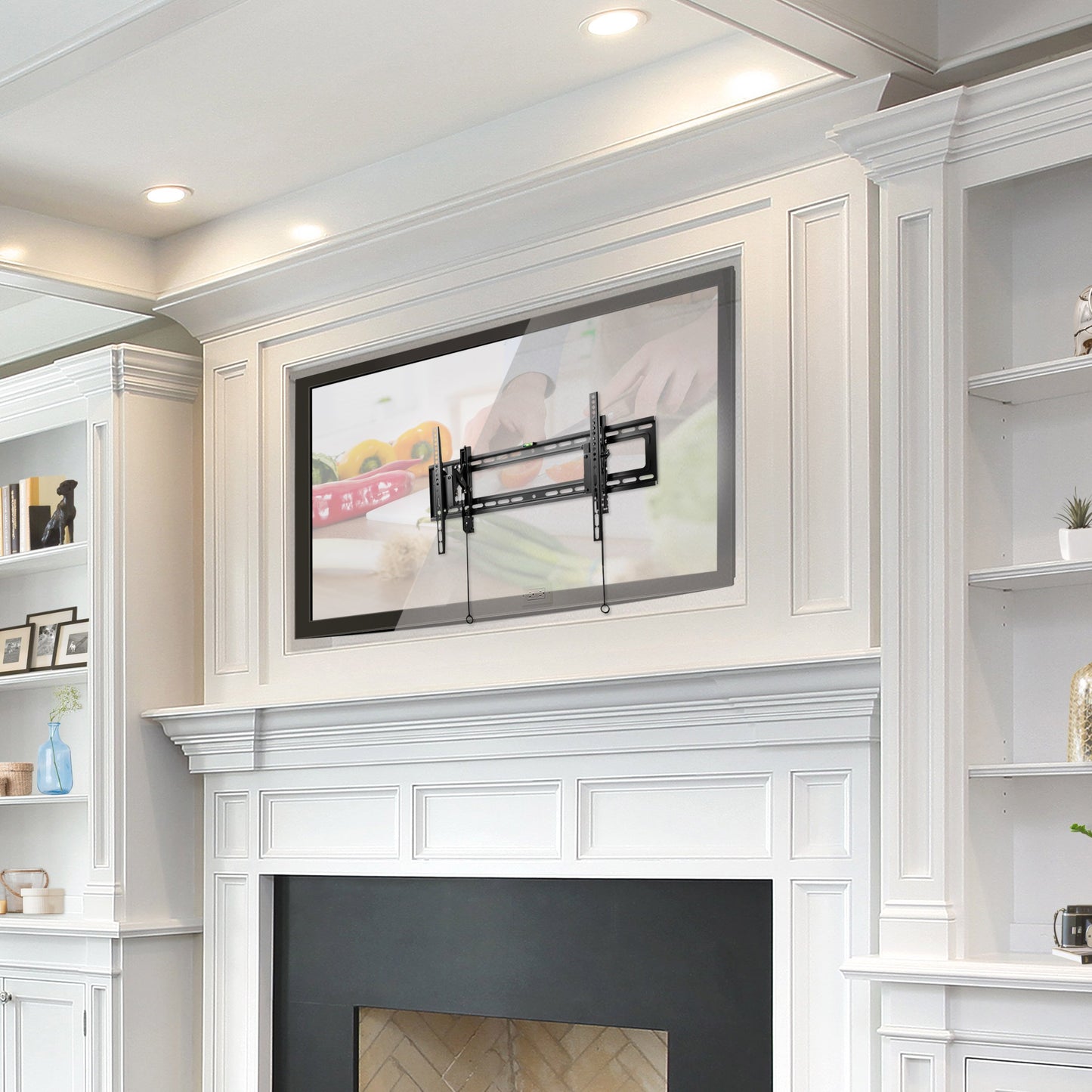 Tilting TV wall mount supporting 43" to 90" TVs, black metal frame with adjustable tilt mechanism, mounted on a beige living room wall, minimalist design with sleek, sturdy construction.