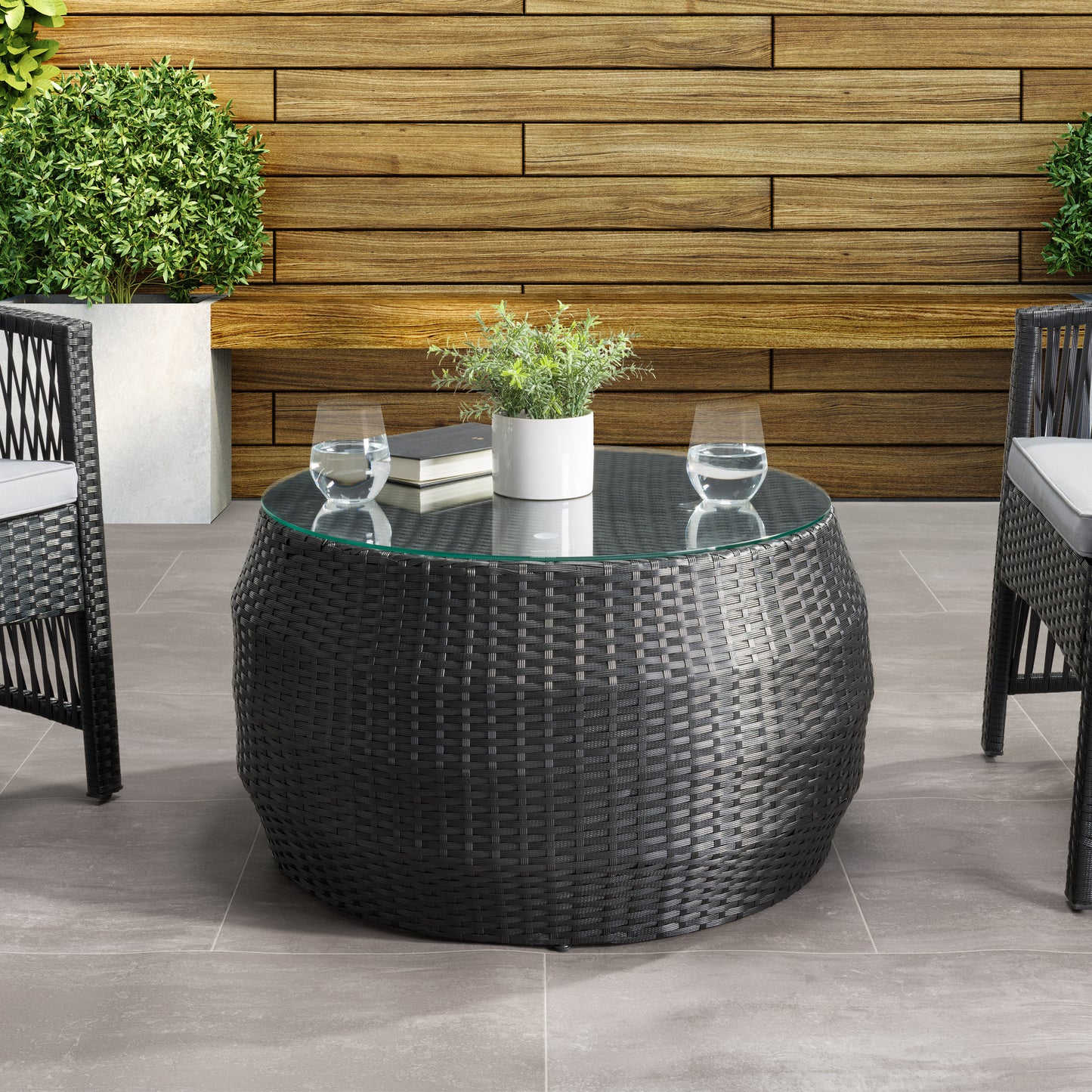 Round wicker patio coffee table with glass top, featuring a natural woven texture and sturdy aluminum frame, perfect for outdoor seating areas.