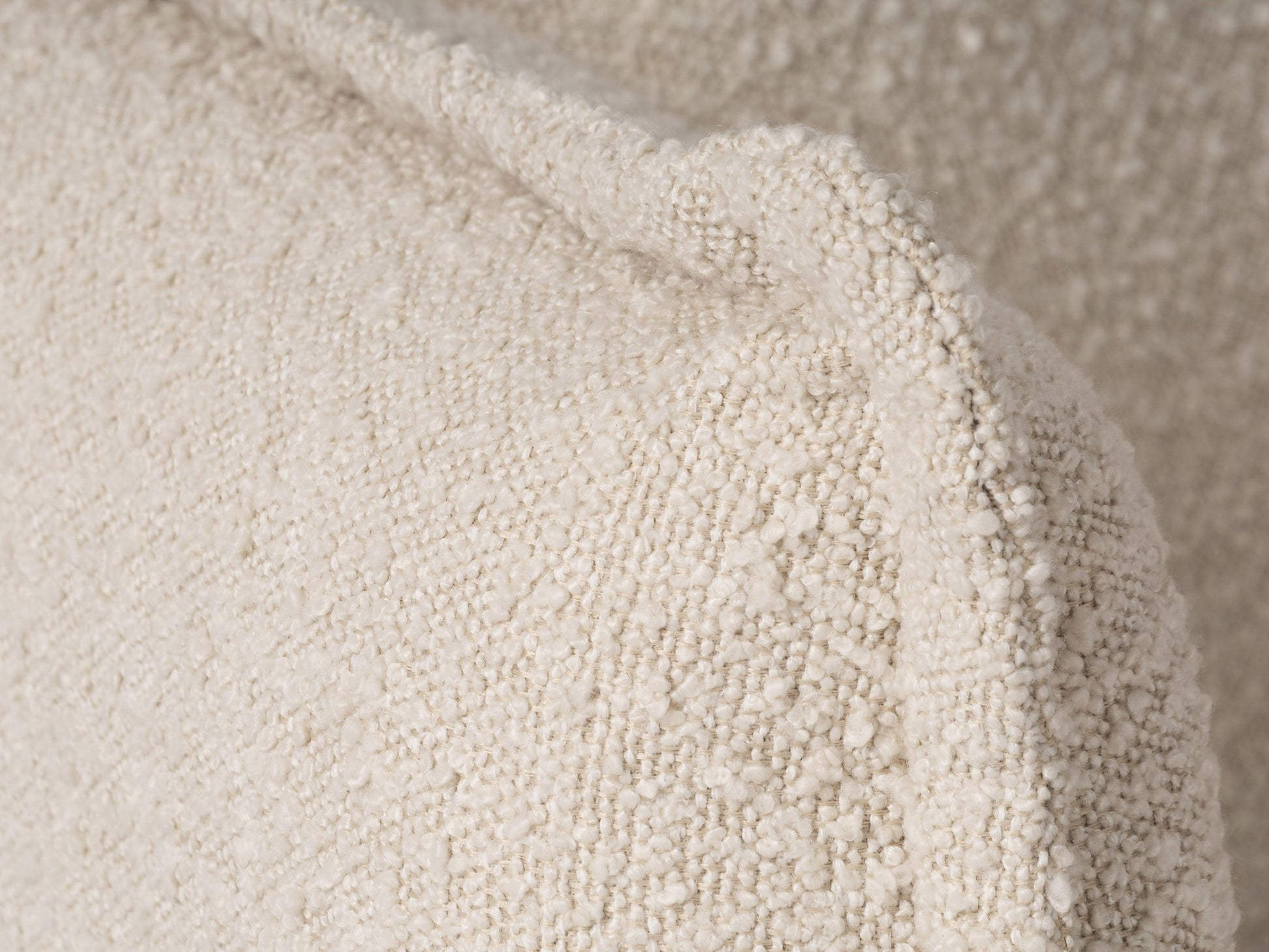 Modern boucle loveseat in cream, featuring soft textured fabric, sleek wooden legs, and plush cushioning for comfort and style, perfect for contemporary living rooms or cozy reading nooks.