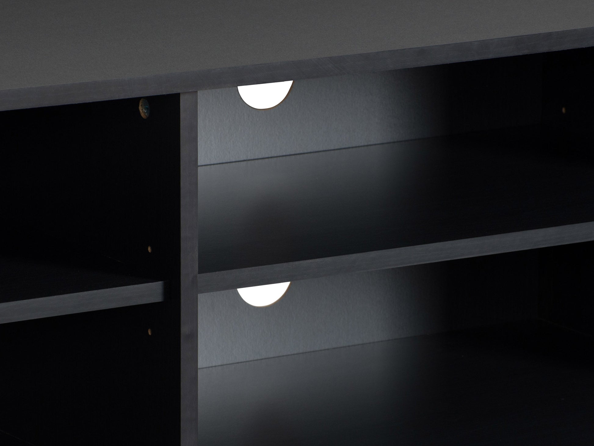 Modern black TV stand for TVs up to 85 inches, featuring sleek lines, minimalist design, and ample storage with open shelves and cabinets. Made of durable materials with a smooth finish.
