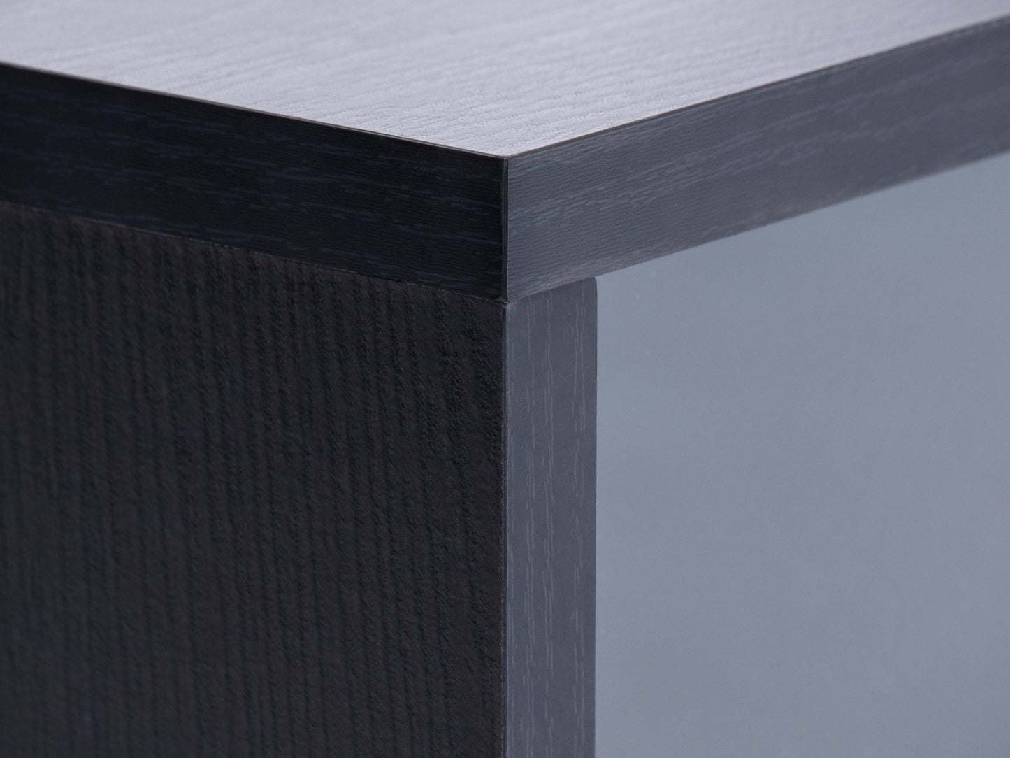 Modern modular TV stand in sleek black wood with adjustable shelves, cable management system, and sturdy metal legs, designed to support TVs up to 110 inches.