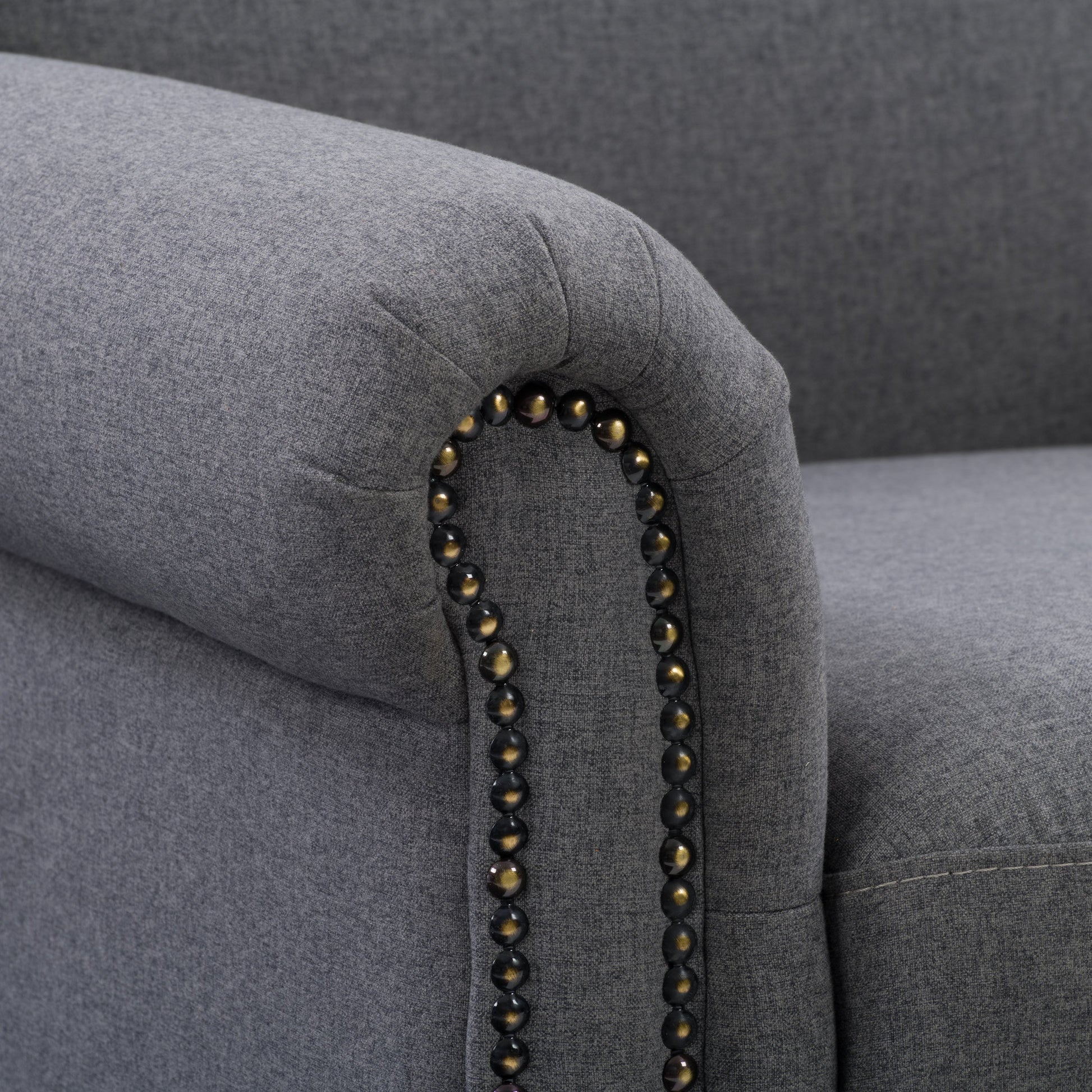Grey armchair with plush upholstery, sleek wooden legs, and tufted backrest. The chair features a modern design with comfortable armrests, perfect for living rooms or offices.