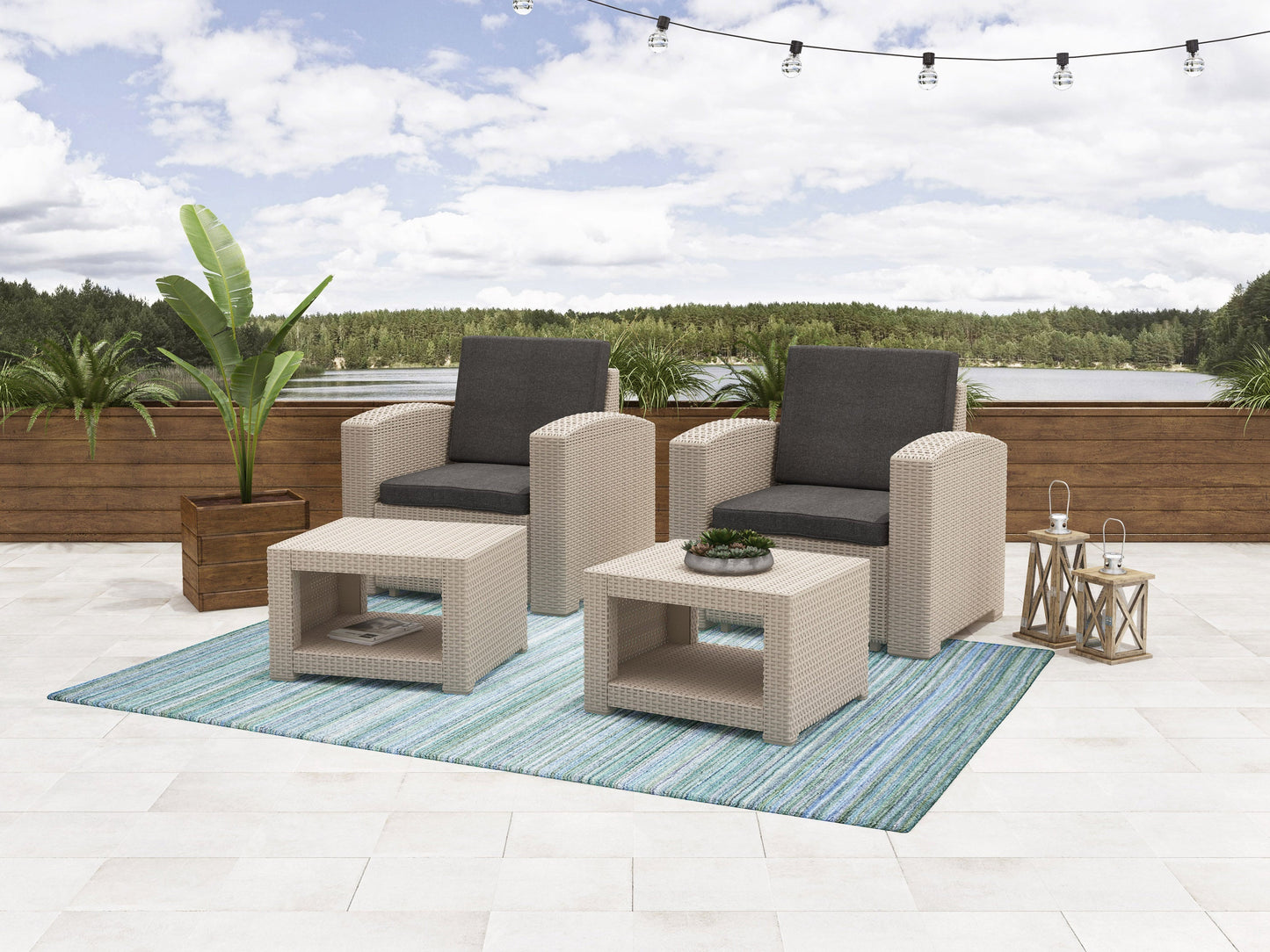 4-piece outdoor patio conversation set with two grey wicker chairs, matching ottomans, and a glass-top coffee table on a wooden deck, featuring plush beige cushions for comfortable seating.