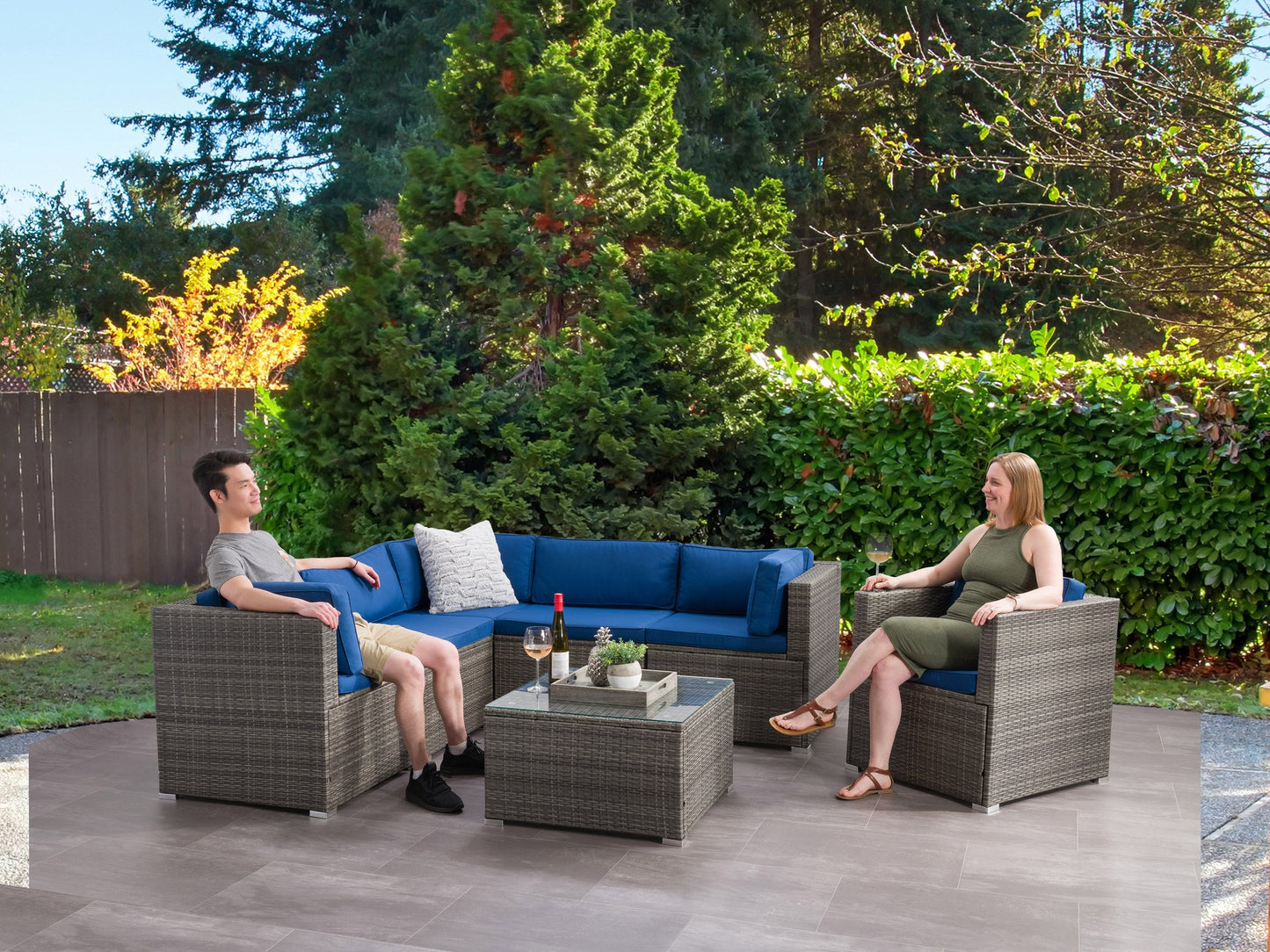 Outdoor sectional set, 7-piece, featuring weather-resistant wicker in a neutral gray tone with plush, water-resistant cushions in beige. Includes modular seating and a glass-top coffee table, perfect for patio relaxation.