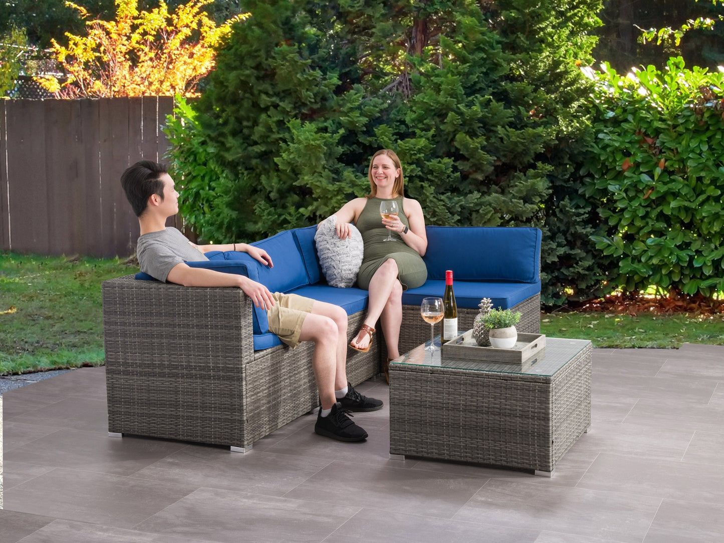 5-piece patio wicker sectional set with beige cushions, brown rattan frame, glass-top coffee table, and modular design for outdoor seating.