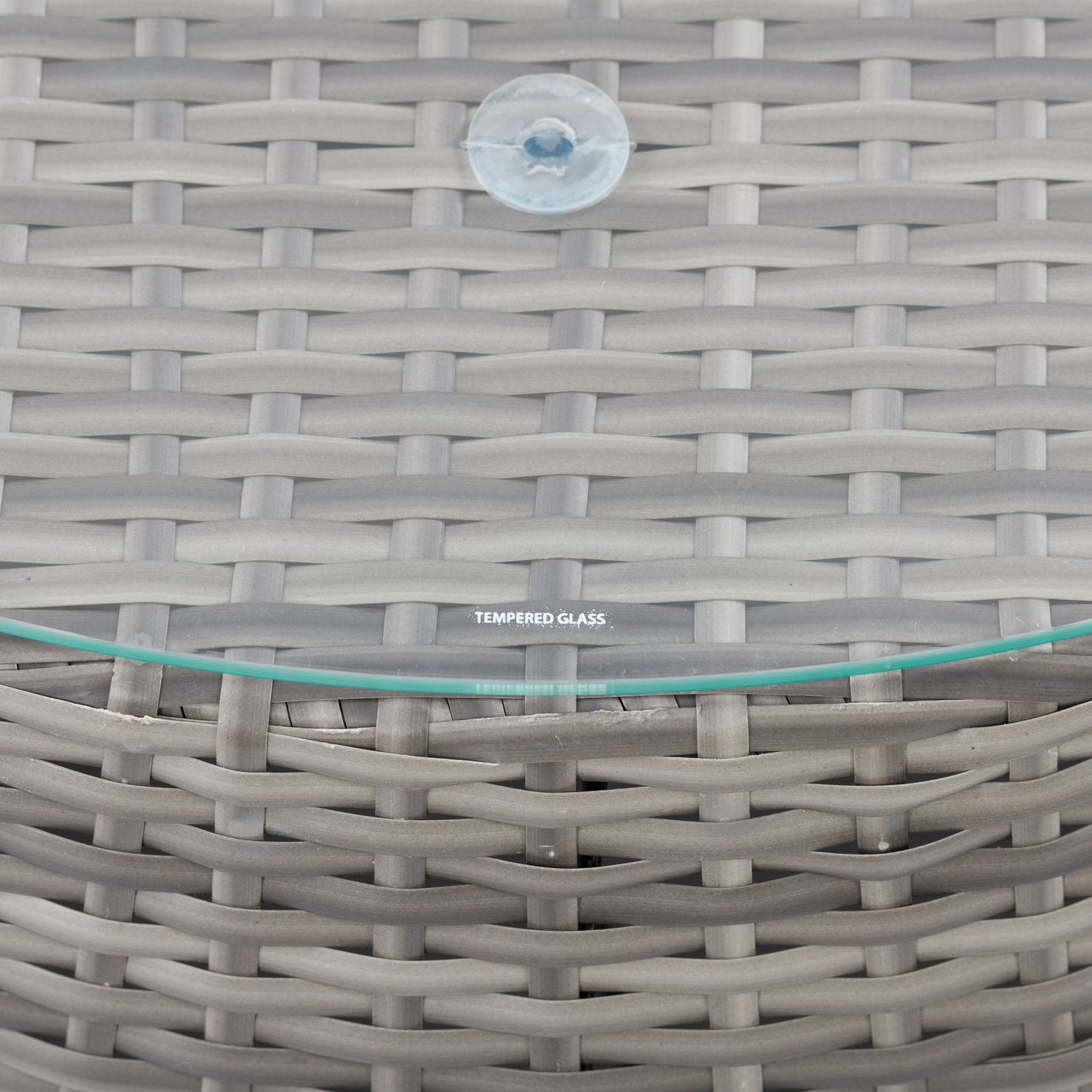 Wicker coffee table with round glass top, natural brown woven wicker base, and sturdy construction, perfect for outdoor patio use.