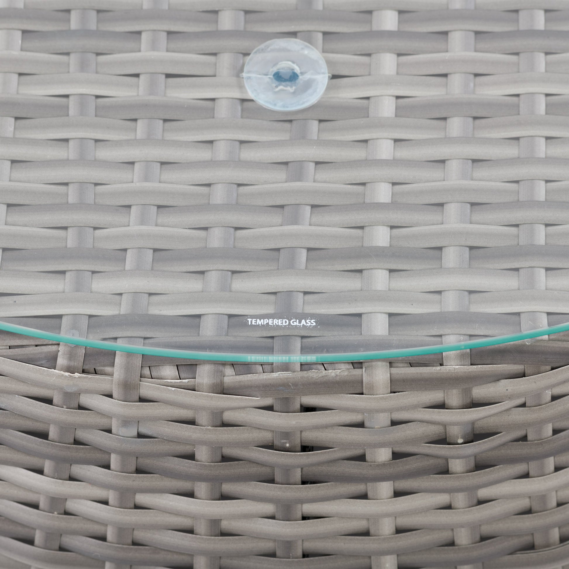 Wicker coffee table with round glass top, natural brown woven wicker base, and sturdy construction, perfect for outdoor patio use.