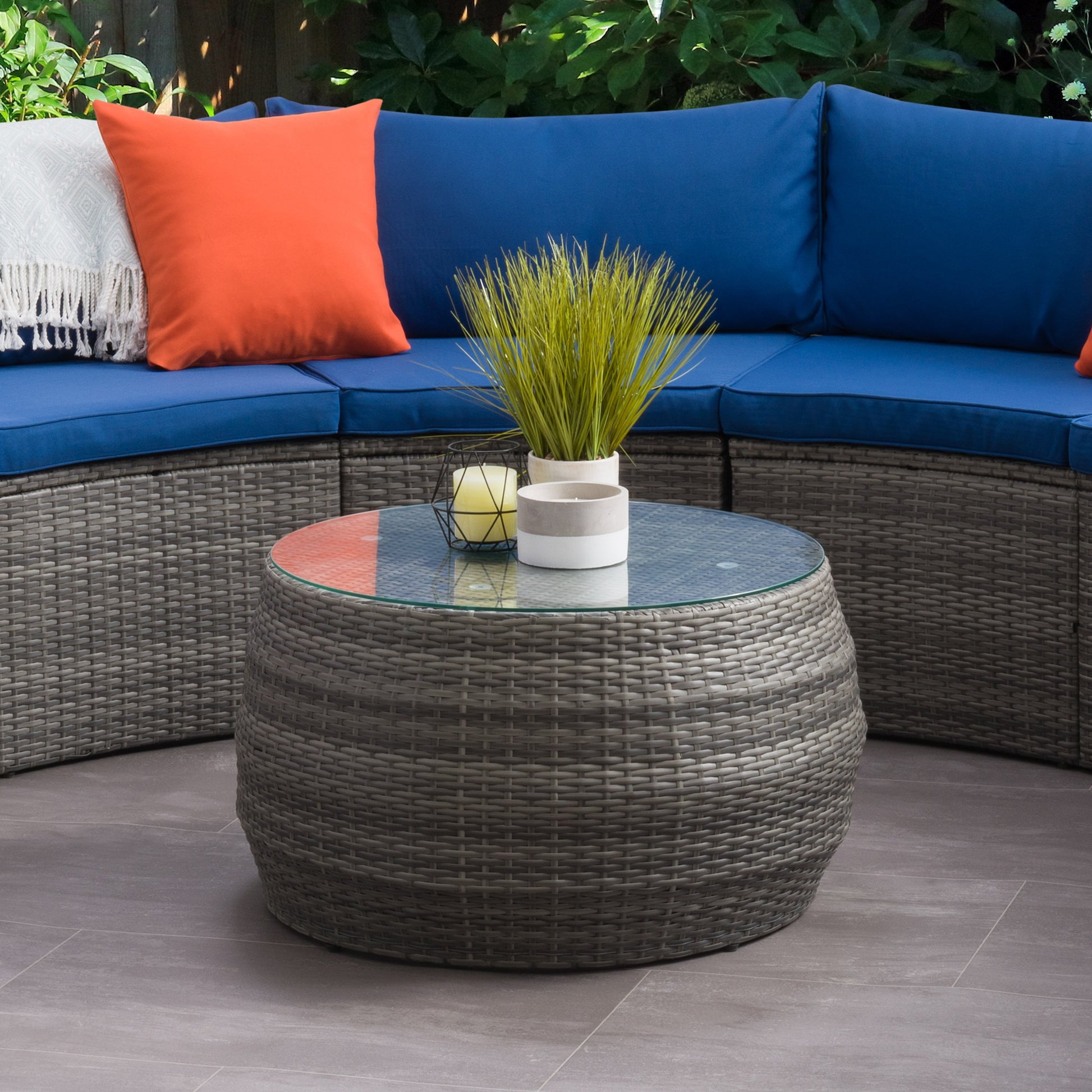 Natural wicker coffee table with glass top, featuring a round design and sturdy rattan construction, perfect for outdoor patio settings. Ideal for stylish, durable, and weather-resistant outdoor furniture.