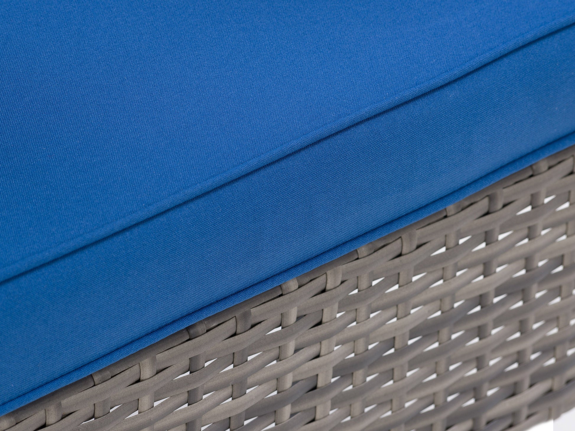 Curved outdoor sectional set in light gray wicker with white cushions, featuring a three-piece design including a round coffee table with a glass top. Ideal for patio or garden seating.